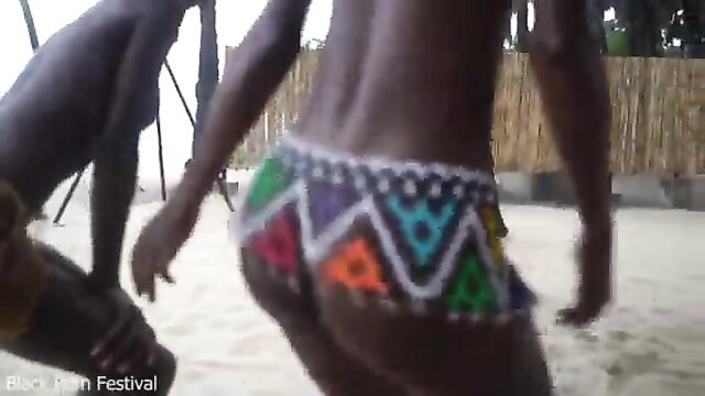 African tribe women in colorful beaded skirts dancing ritual on beach