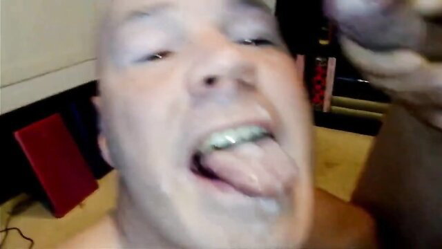 Bald man with braces sticks out tongue in close-up amateur oral tease