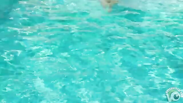 Blurry turquoise pool water with partial nude body swimming nude