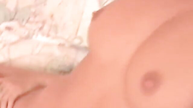 Nude blonde model topless closeup, perky tits on sofa