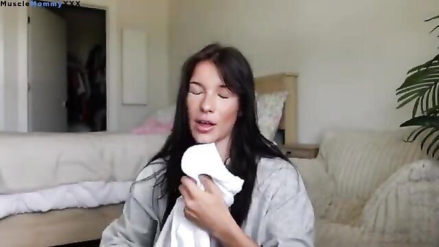 Brunette beauty holding white cloth to mouth in bedroom vlog tease