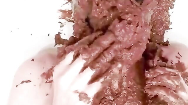 Extreme scat closeup: woman's face smeared in thick brown shit, hand pushing it down throat