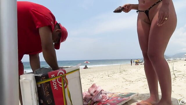 Woman in a small bikini on the beach with a vendor