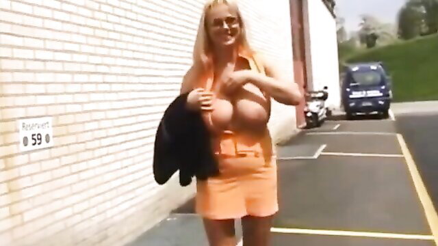 Blonde mature German woman with huge tits in tight orange mini dress outdoors