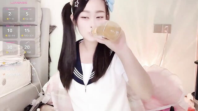 Asian camgirl Yueyue2003 drinks from bottle in schoolgirl uniform
