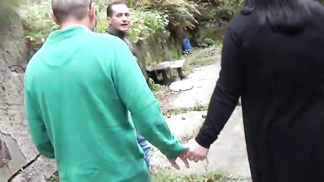 Pamela De Boni holds hands with 2 men outdoors before fellatio