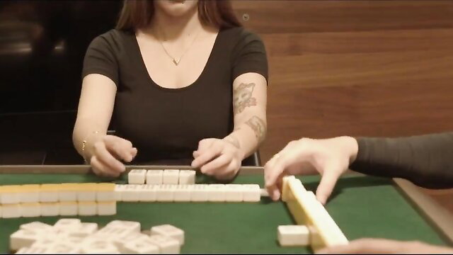 Petite Asian girlfriend playing mahjong in tight top, tattooed arm