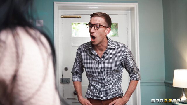 Shocked nerdy guy with glasses stares wide-eyed at woman at door