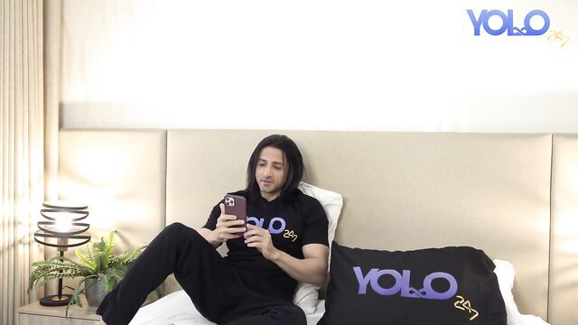 Niks Indian lounging sexy in YOLO shirt, long hair Desi stud