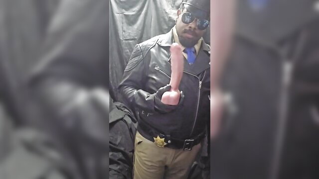 Learubbon as leather cop holding pink dildo, sexy uniform tease