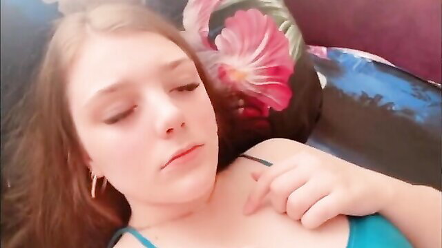 Beautiful teen in bed, topless with lingerie strap down, seductive eyes closed