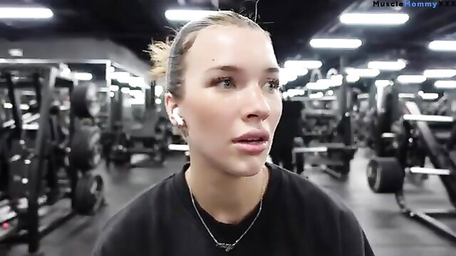 Fit blonde MILF Mommy in gym, black top, ponytail, AirPods workout