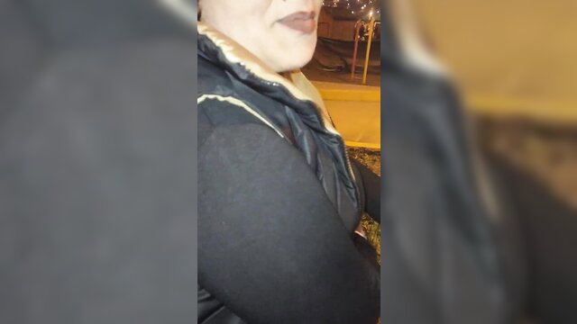 Blurry closeup of mature Venezuelan woman in puffy jacket at night
