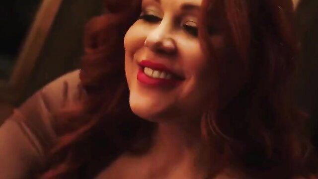 Maitland Ward smiling seductively with red lips and wavy red hair