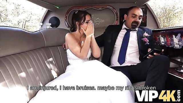 Bruised bride in wedding dress cries in limo with suited husband watching