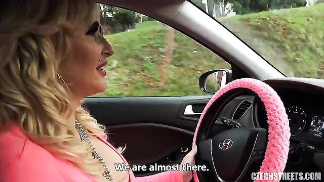 Blonde bombshell Barbie driving in tight pink dress, big tits spilling out