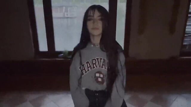 Asian schoolgirl in Harvard hoodie kneels in dark abandoned spot