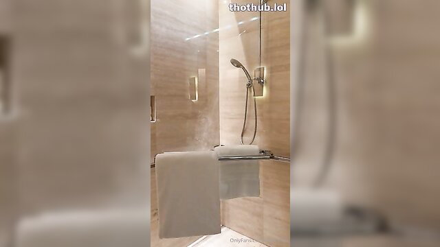 Mia Khalifa in steamy hotel shower, nude body blurred behind glass