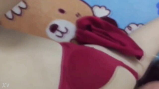 Asian woman in red bra lingerie teases with teddy bear on bed