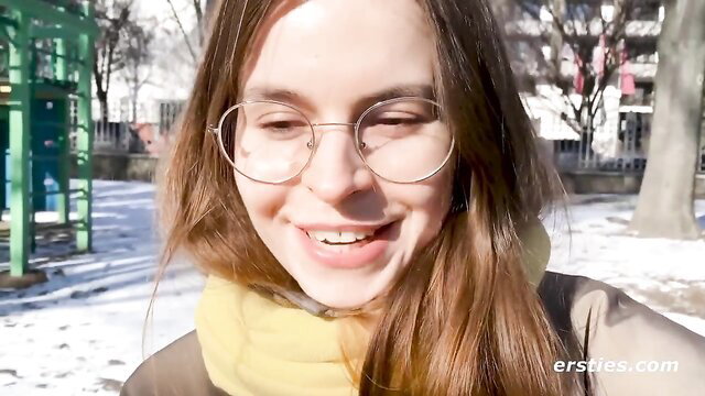Smiling German babe Daniela with glasses on snowy park playground