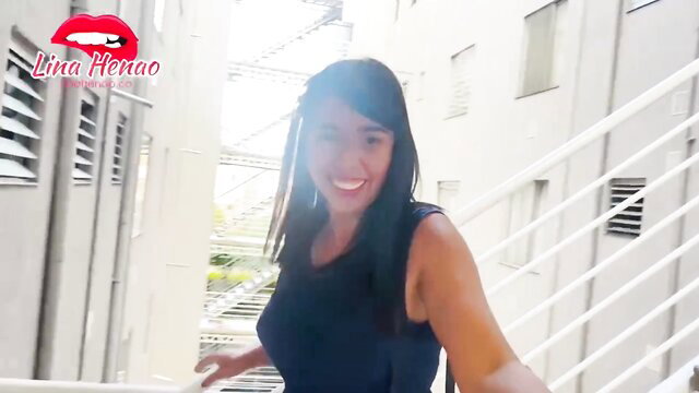 Lina Hernao smiling in tight dress on stairs, public squirt toy tease