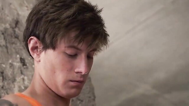 Closeup of young twink with short brown hair, piercing gaze in BB Fucking Boys