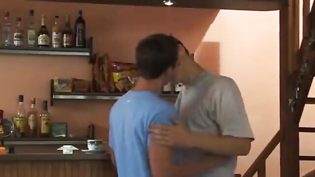 Two fit young men passionately kissing in kitchen scene