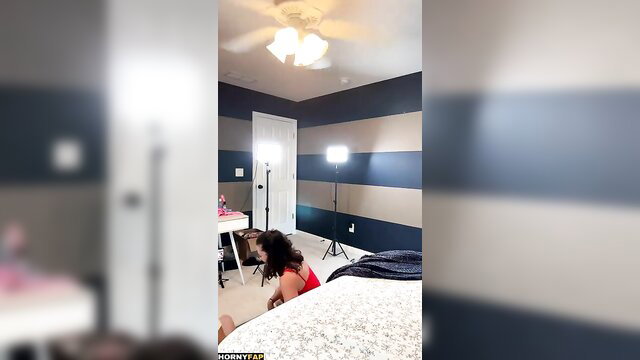 Peachy Babe brunette bends over bed in red bikini for lesbian dildo play