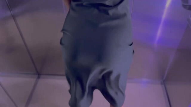 Japanese woman in tight gray dress dances seductively in glass booth