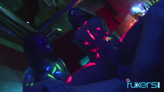 Neon-lit black babes in glowing threesome orgy