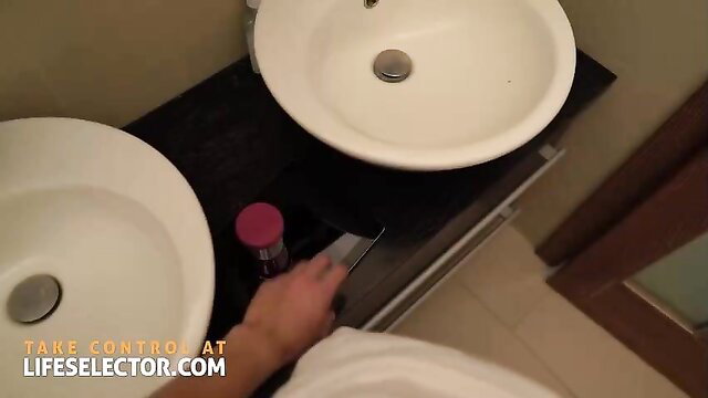 Shalina Devine blonde in bathroom holding knife & pink jar over sinks