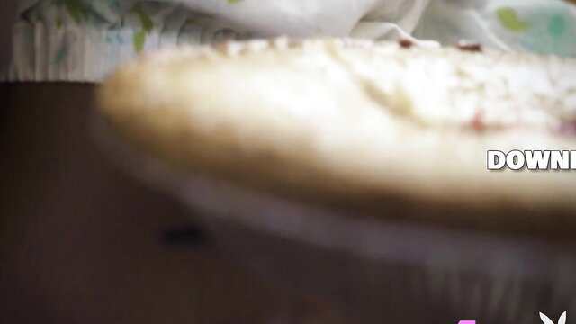 Beautiful black babe in apron cooking pizza, teasing cleavage