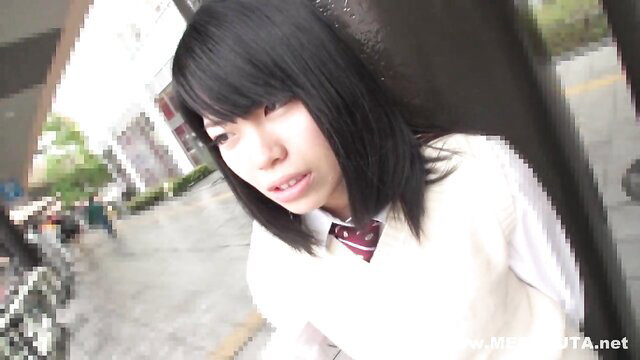 Japanese schoolgirl in uniform at outdoor bus stop, closeup face view