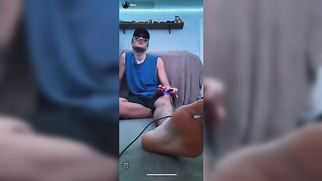 Hot guy gamer soles in tank top and shorts, bare feet up close