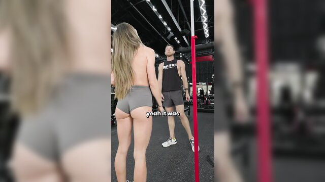 Blonde gym girl in tight shorts with male trainer grabbing her big ass