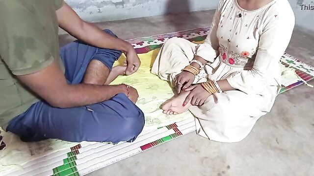 Indian man touches feet of village bhabhi in salwar kameez on mat