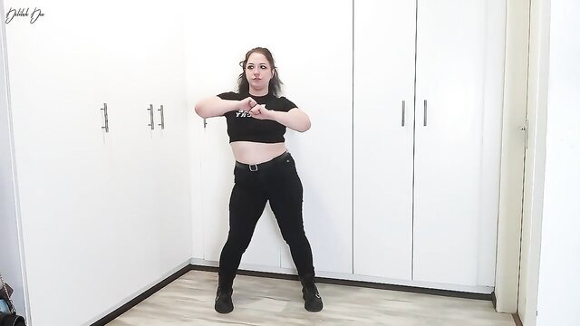 Humiliatrix in crop top and tight pants poses dominantly, burping fetish tease