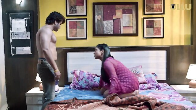 Sexy Indian babe in sheer pink top kneels before shirtless hunk on bed