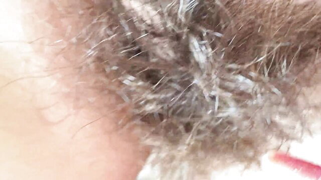 Closeup of woman's hairy bush and pink labia lips in erotic fetish thumbnail
