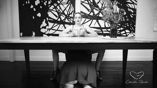 Amber Moore in lingerie reading erotic book, seductive pose