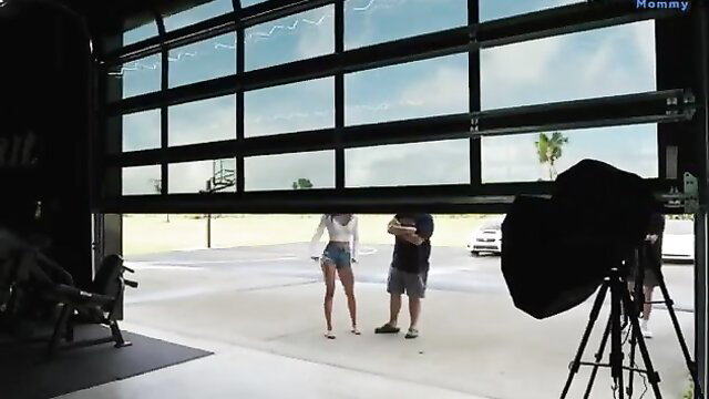 Bryce Adams in tiny denim shorts and crop top on car lot photoshoot