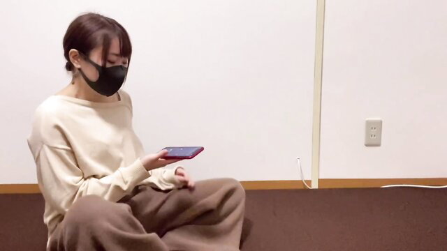 Japanese amateur YouTuber in mask holds phone, sits clothed pre-sex