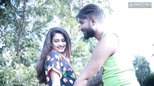 Indian bhabhi in polka dot saree smiles at muscular devar in green tank top outdoors