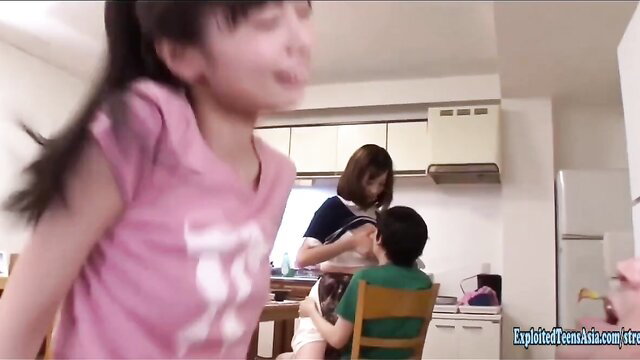 Skinny Asian 18yo girl with ponytail in pink top in kitchen scene