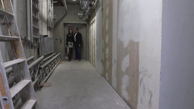 Kira Parvati in tight dress with man in construction hallway MMV Films