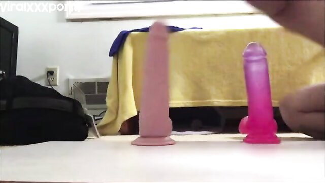 Two realistic dildos: large pink and purple on table in steamy anal prep