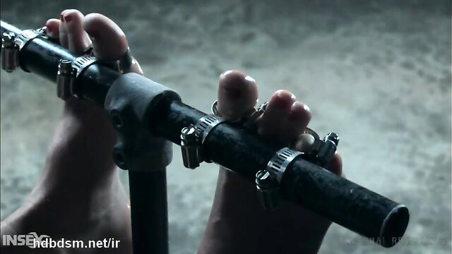 Busty blonde's bare feet clamped in metal bondage crying in pain