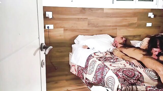Tattooed man fucks busty brunette missionary on bed