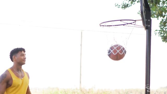 Slim black trans man shooting basketball in yellow tank top
