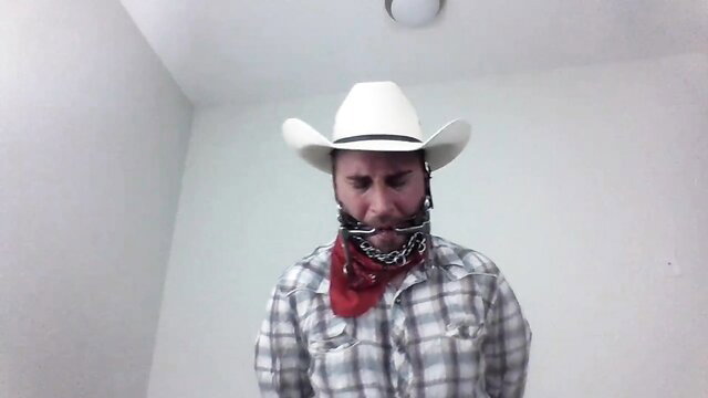 Bitgagged cowboy in hat and chains, gagged fetish tease